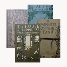 Four vintage books with decorative covers on a white background