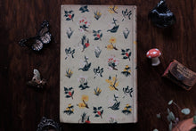 Floral-patterned book on a wooden surface with decorative items.