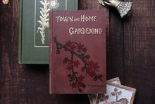 Vintage book titled 'Town and Home Gardening' on a wooden surface with other books and cards.