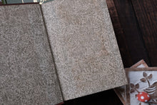 Open book with patterned end-paper lying on a wooden surface