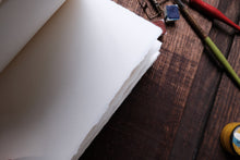 White paper on a wooden surface with drawing tools
