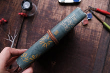 Decorative rolled-up paper with text and designs on a wooden surface