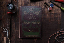 Book titled 'Mig and Her Friends' on a wooden surface with decorative items.