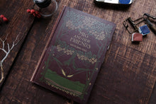 Book titled 'Mig and Her Friends' by Edith King Hall on a wooden surface with decorative items.