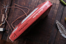 Red box with 'Secret Garden' text on a wooden surface