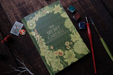 Book titled 'The Secret Garden' with decorative elements on a wooden surface.
