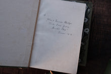 Handwritten text on a piece of paper inside an open book
