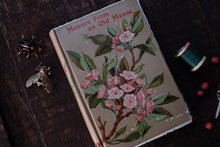 Vintage book with floral design on a wooden surface