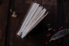 Open book with white pages on a dark wooden surface