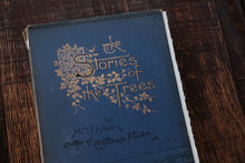 Vintage book titled 'The Stories of the Trees' on a wooden surface