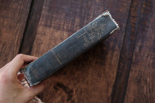 Vintage leather-bound book held against a wooden background