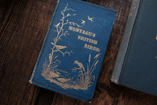 Blue book titled 'Montagu's British Birds' on a wooden surface