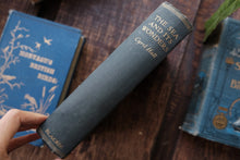 Book titled 'The Sea and Its Wonders' by Cyril Hall on a wooden surface with other books.