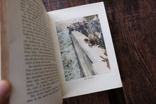 Open book with a colored illustration on a wooden surface