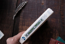 Spine of 'Flower Fables' book by Louisa M. Alcott on a wooden surface with other books.