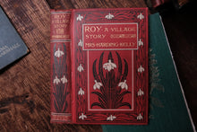 Red book titled 'A Village Story' by Mrs. Harding Kelly on a wooden surface