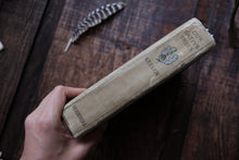 Hand holding a vintage-style box with 'Keller' branding on a wooden surface.