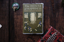 Book titled 'The House of Happiness' by Kate Langlee Bosher on a wooden surface.