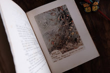 An open vintage book lying on a dark wooden surface, showing an illustrated page with a fantasy scene and printed text. A small butterfly decoration and part of a pencil are visible near the top right.